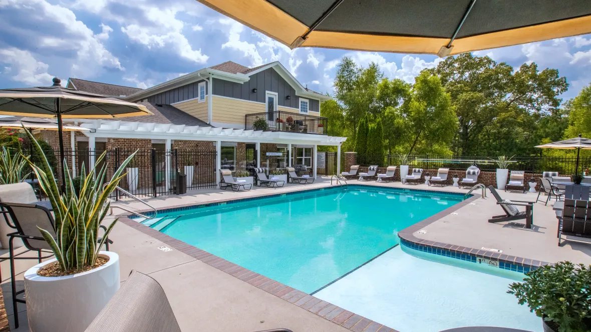 Around the gated pool, there is a variety of seating options ranging from sun loungers to tables and Adirondack chairs, offering a perfect spot for relaxation and socializing.