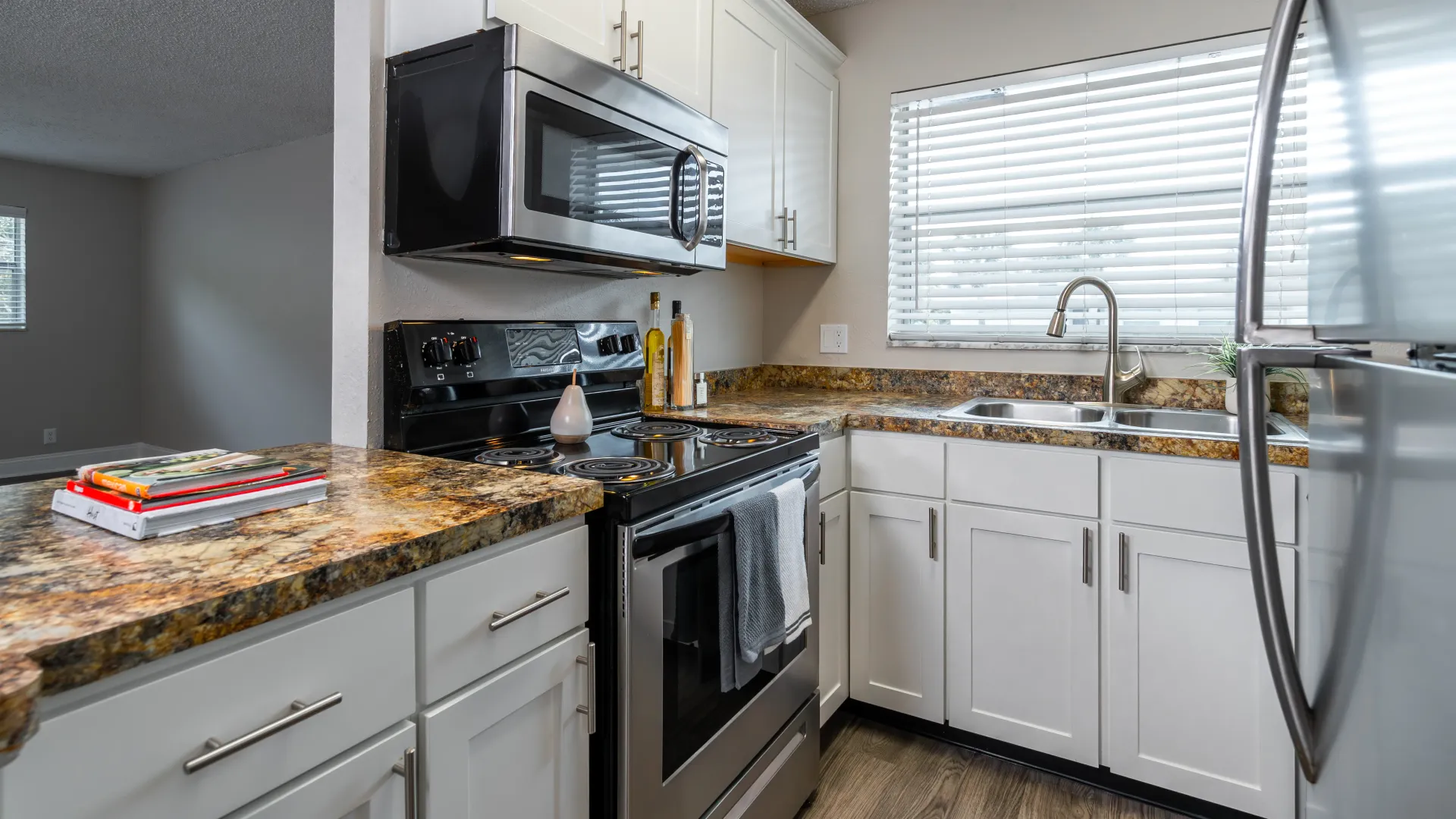  A charming kitchen with a stunning countertop seamlessly extending into a practical prep area and breakfast bar, ideal for mingling and meals.