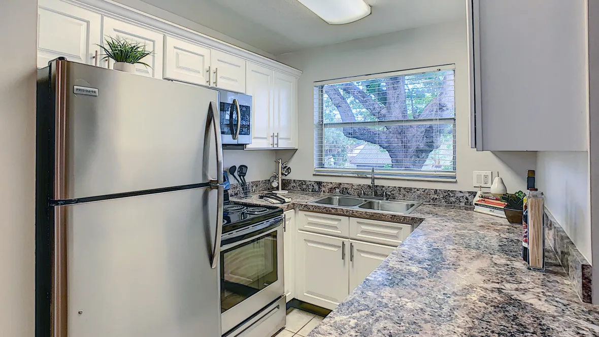 A stylish kitchen setup boasting a refrigerator, stove, microwave, and dishwasher – the secret to culinary mastery.