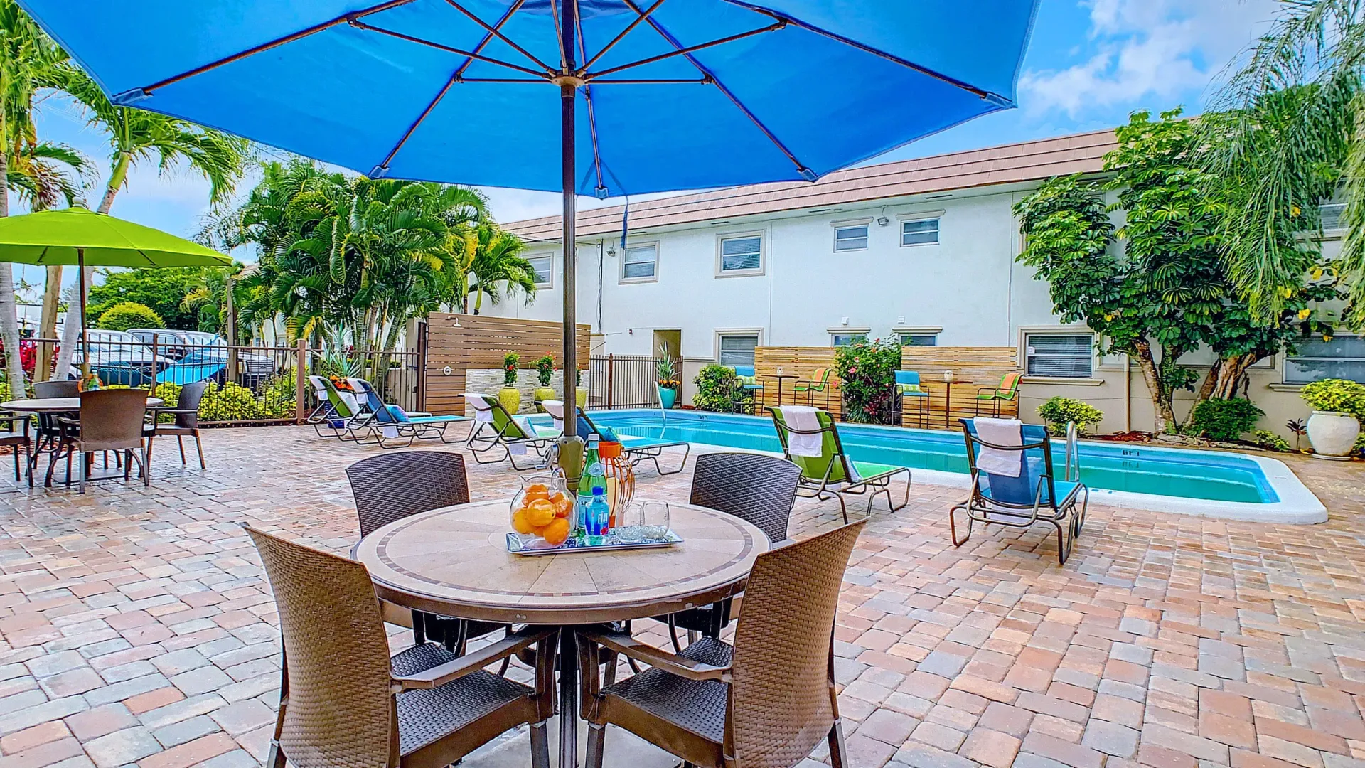 Vibrant umbrellas shading dining tables on the inviting pool deck offering a spot to dine and relax under the shade.