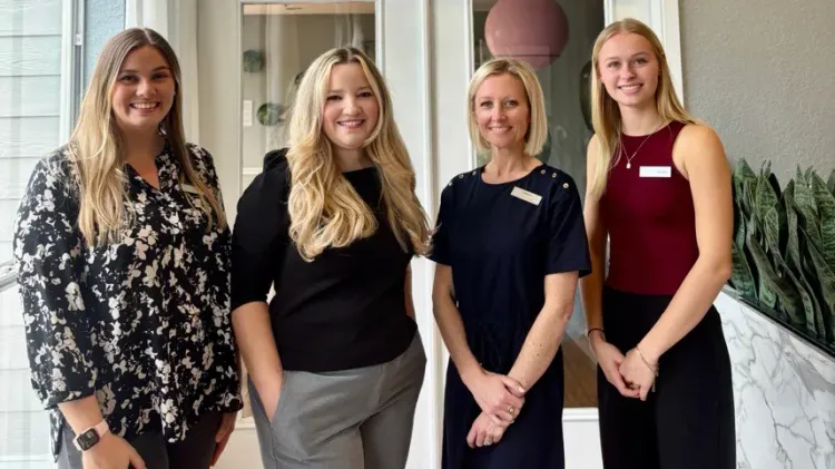 Four leasing staff members standing inside the Eden Pointe leasing office.