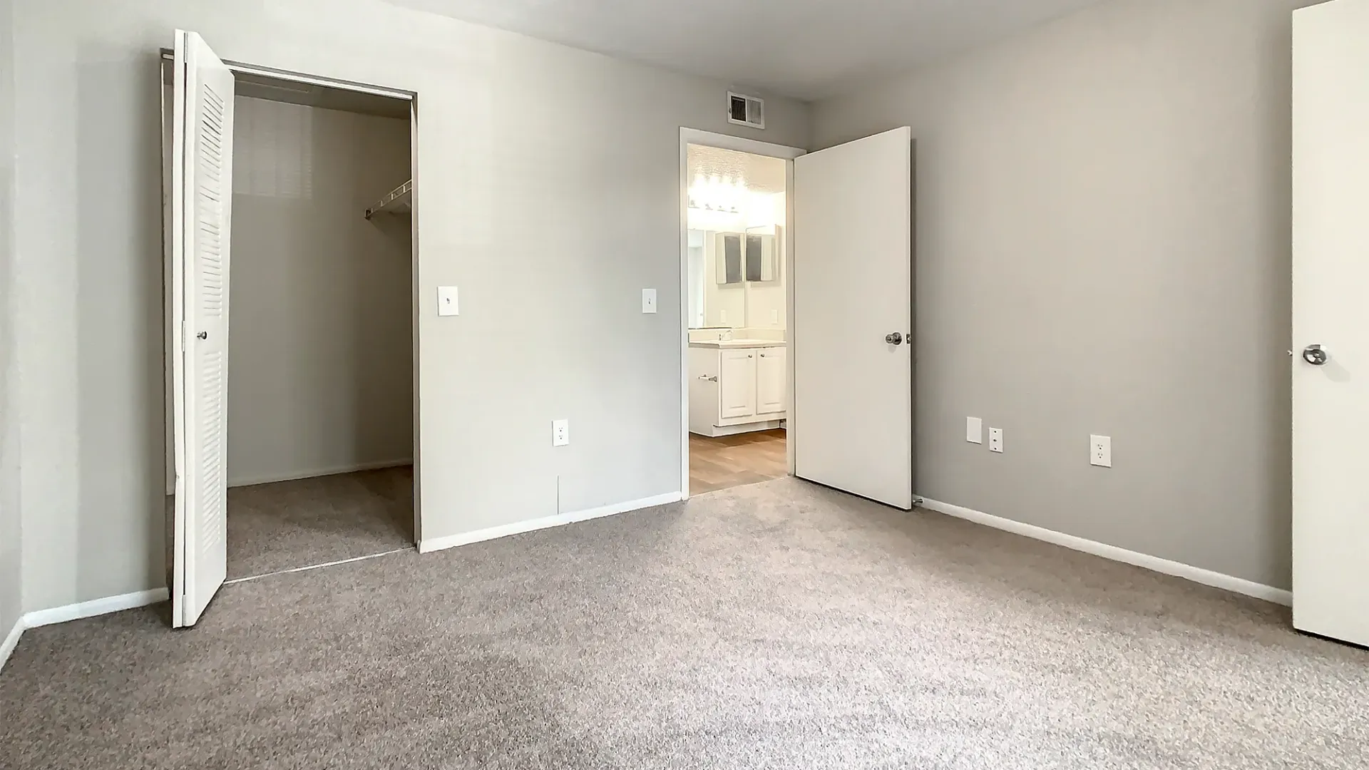A bedroom with plush carpeting and large closet