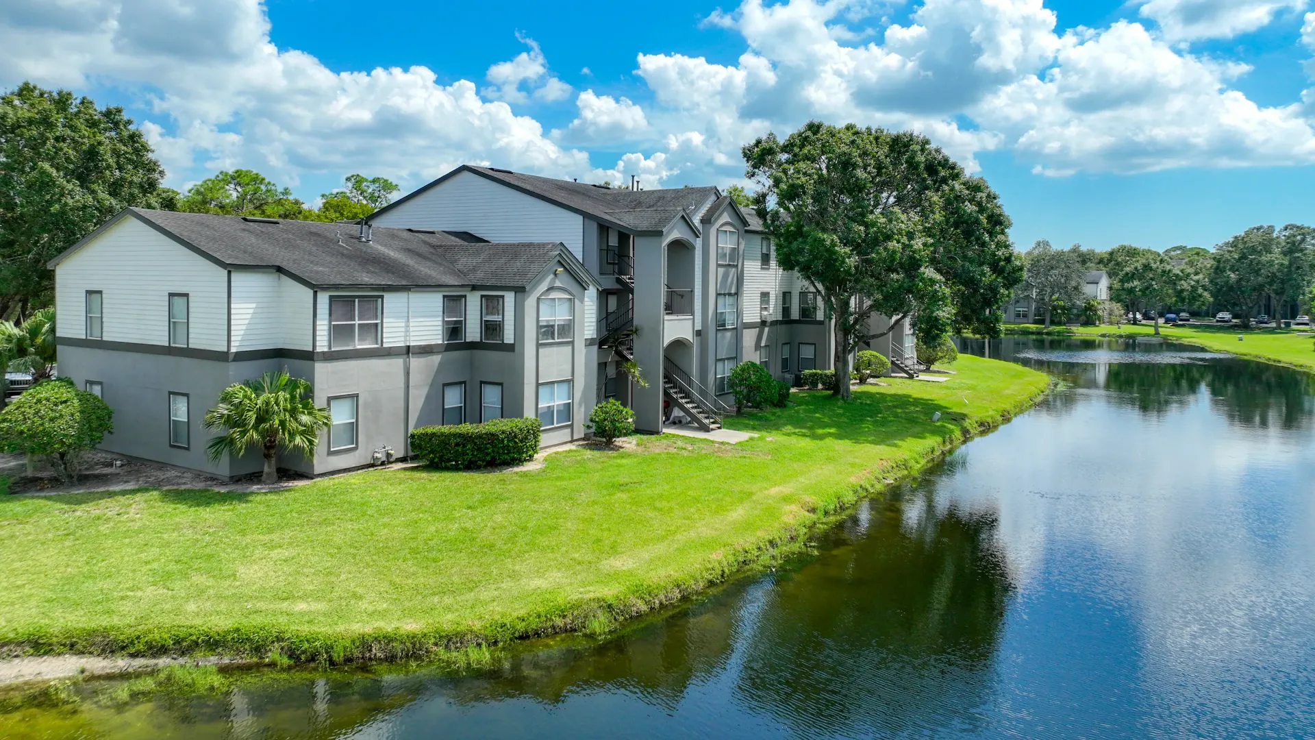 Beautiful building exterior with a serene lake view at Eden Pointe Apartments.