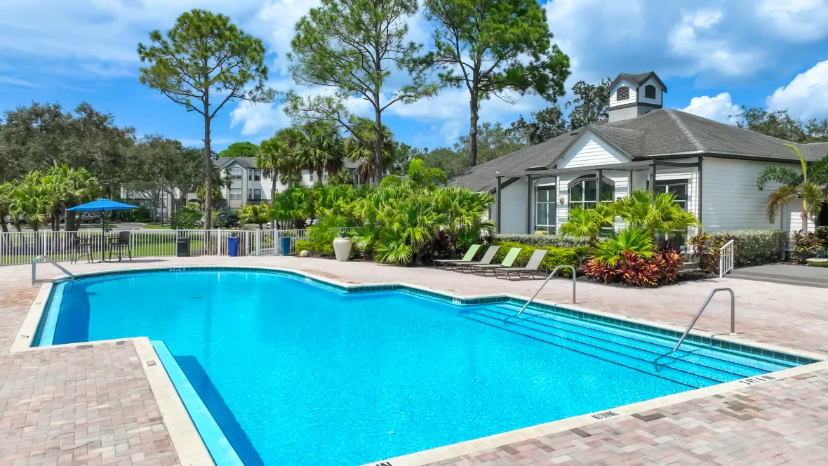 The community pool, surrounded by loungers and tables with umbrellas.