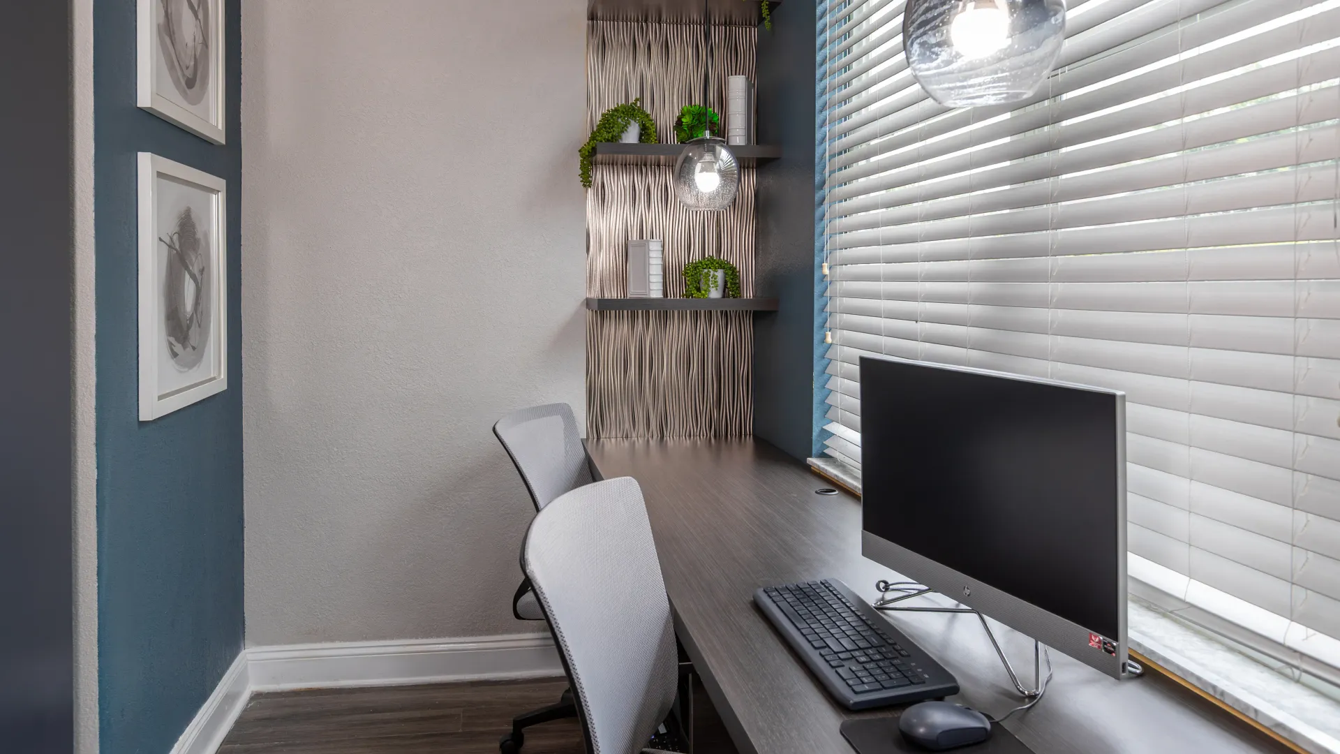 Contemporary business center with computer stations, shelving, and accent lighting at Ashton Chase Apartments.