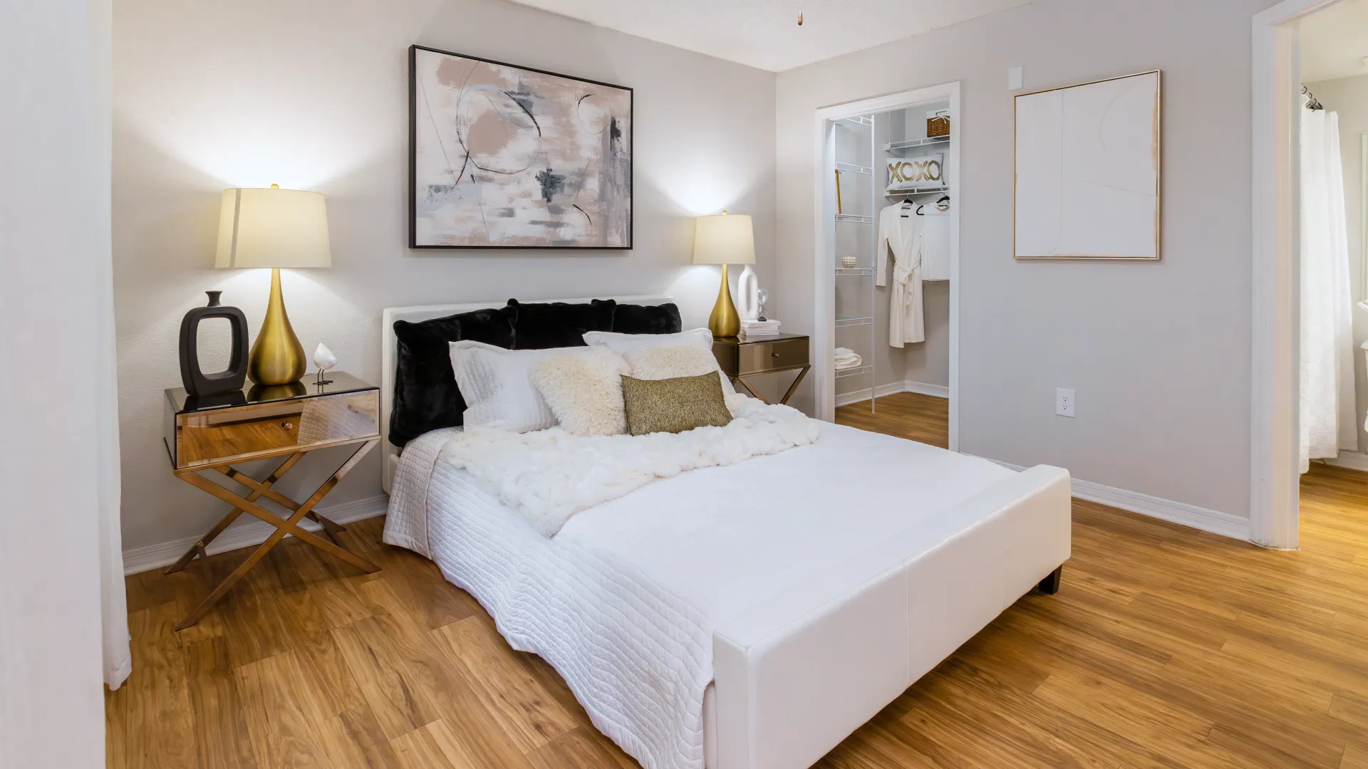 Master bedroom at Ashton Chase Apartments featuring neutral decor, wood-style flooring, and a spacious walk-in closet.