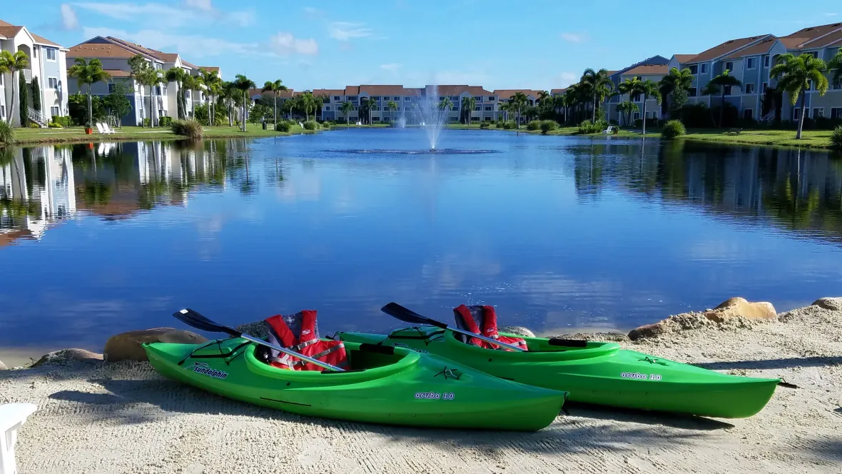 Two kayaks equipped with paddles and floatation vests, ready for residents to enjoy on the water.
