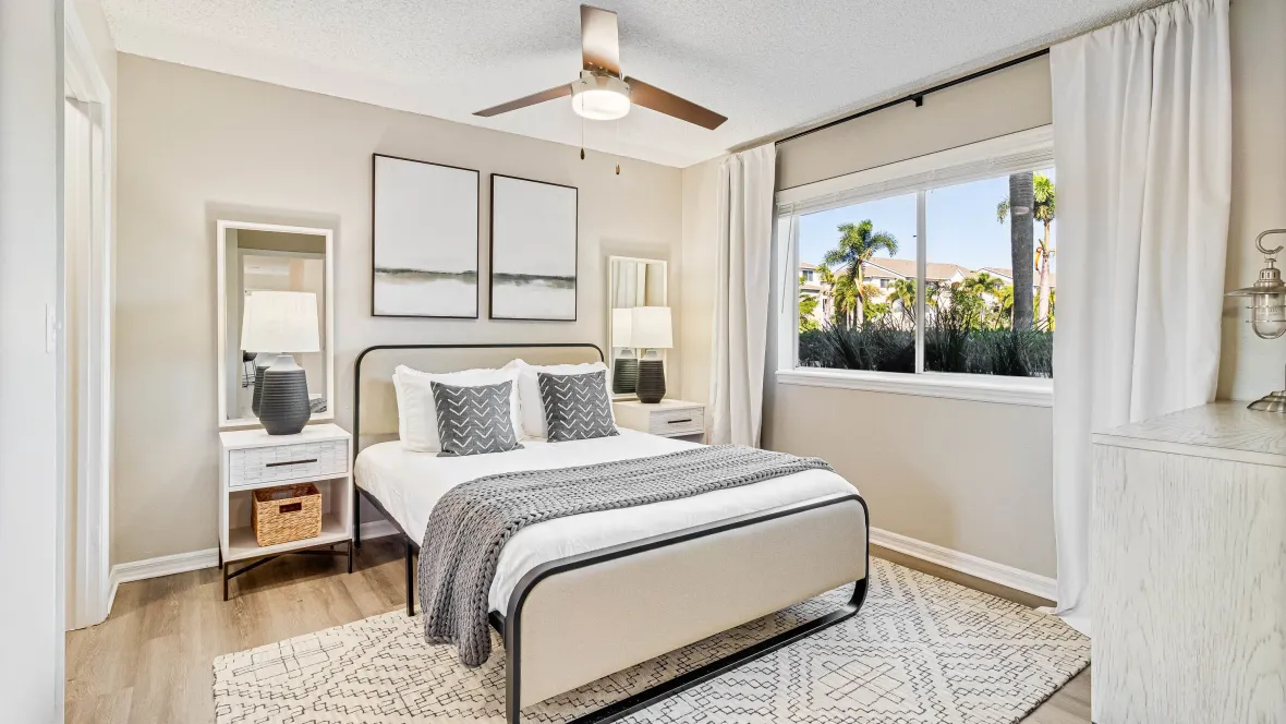  A serene master bedroom with an overhead ceiling fan above a king-sized bed offering a cozy retreat.