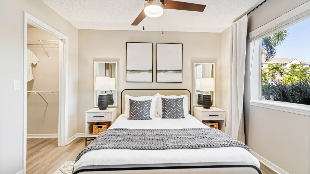 A generous bedroom with an advantageous ceiling fan offering breezy comforts, and closets are carefully organized for maximum wardrobe storage. 