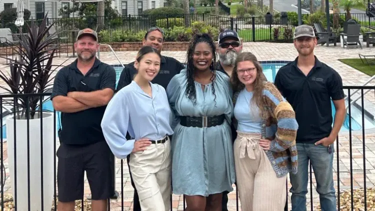 Ridgemar Commons staff gathered outdoors near the community pool.