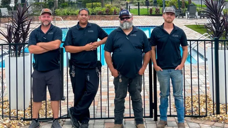 Maintenance crew at Ridgemar Commons Apartments standing in front of the resort-style pool area.