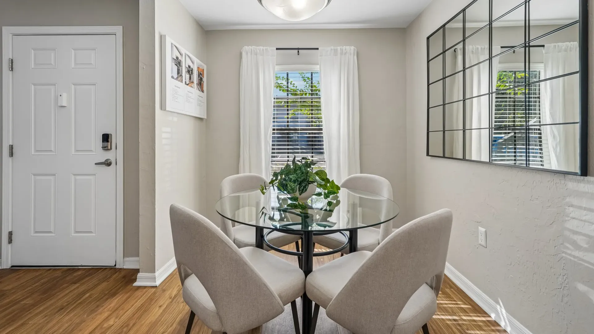 Dining area at Ridgemar Commons featuring a round dining table, upholstered chairs, wood-style flooring, and a large window with natural light.