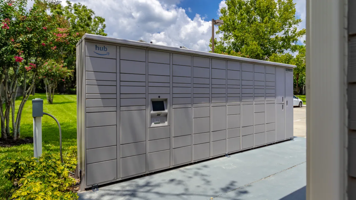 A wall of small to extra-large sized lockers for safe and secure Amazon shopping package delivery convenience. Hub is located outdoors for access anytime.