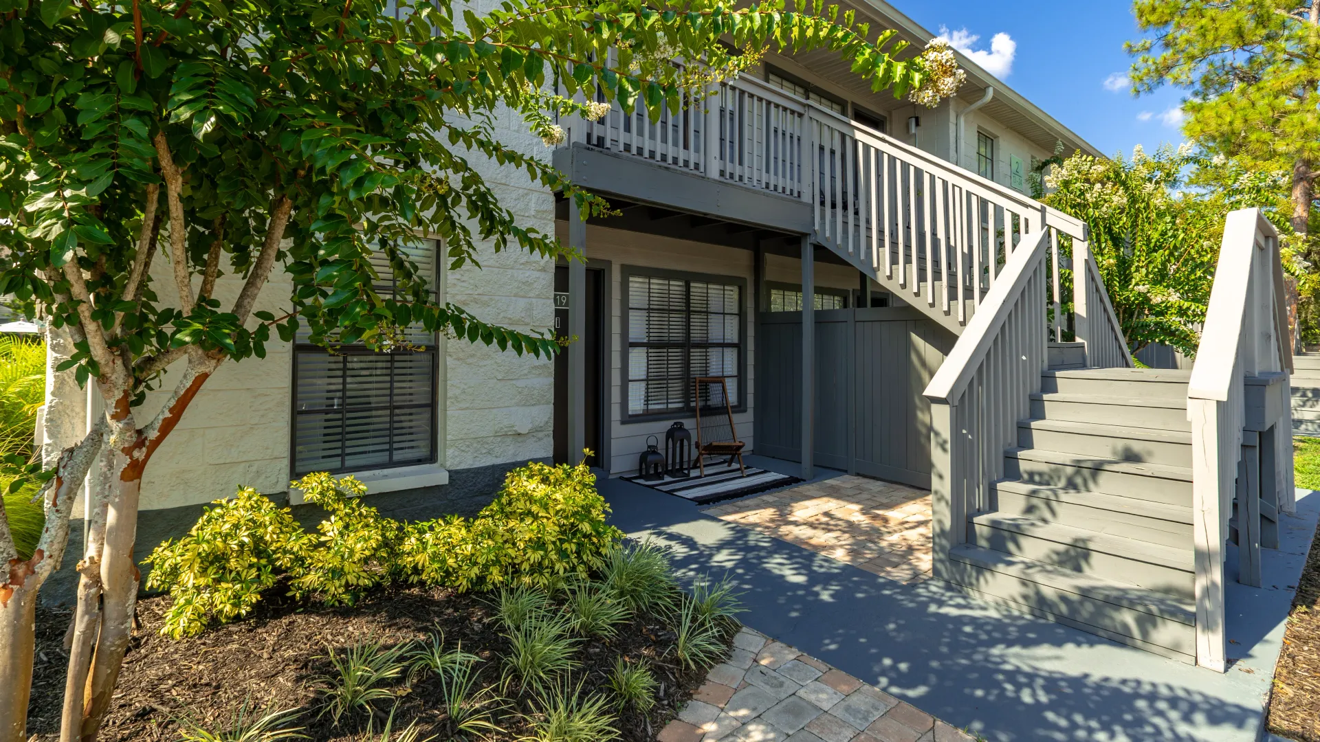 A freshly painted, two-story apartment building surrounded by lush landscaping