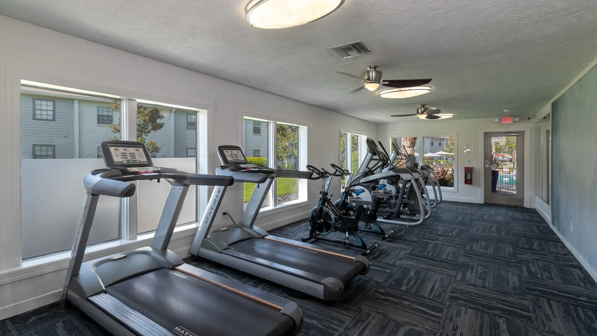 A line of treadmills, spin bikes, and ellipticals in the fitness center 