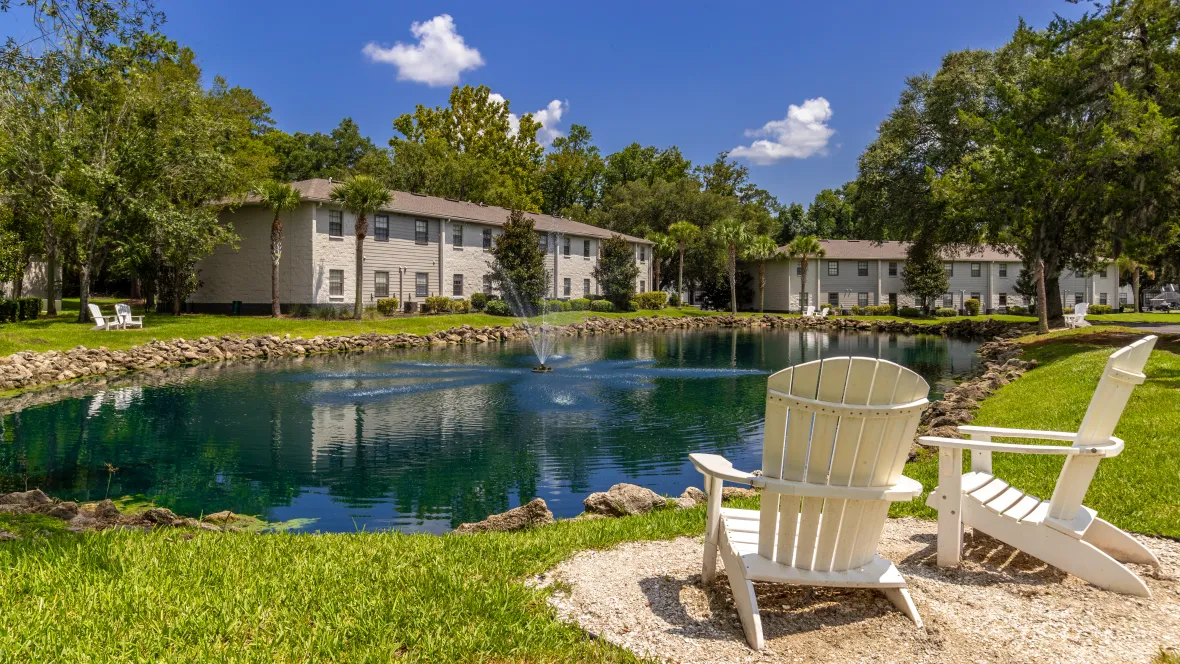 Adirondack chairs set up to provide residents with scenic views of the pond, creating a serene and relaxing environment.