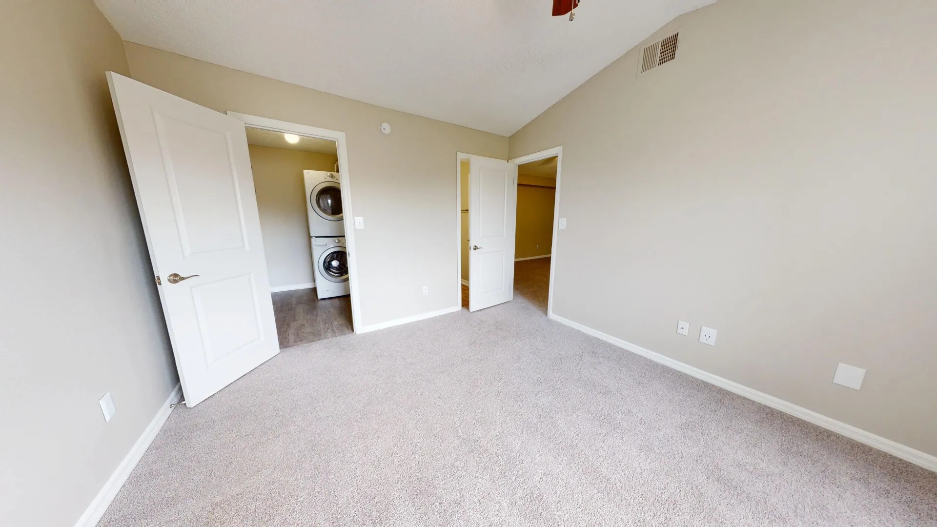 Bedroom in The City floor plan at Ridgemar Commons featuring plush carpeting, neutral walls, an open layout, and access to an in-home washer and dryer.