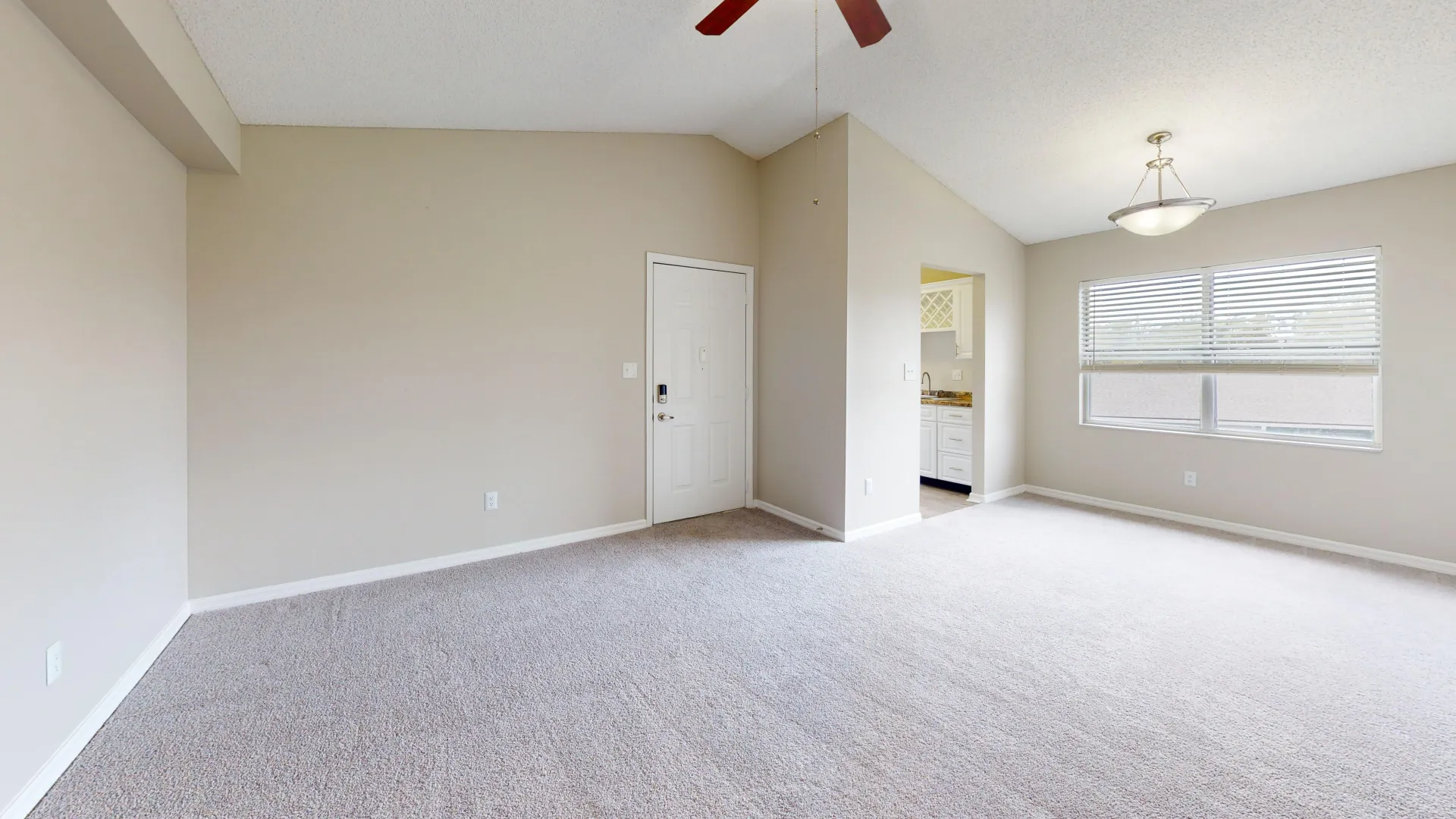 Open-concept living and dining area in The City floor plan at Ridgemar Commons featuring plush carpeting, large windows, high ceilings, and a spacious layout.