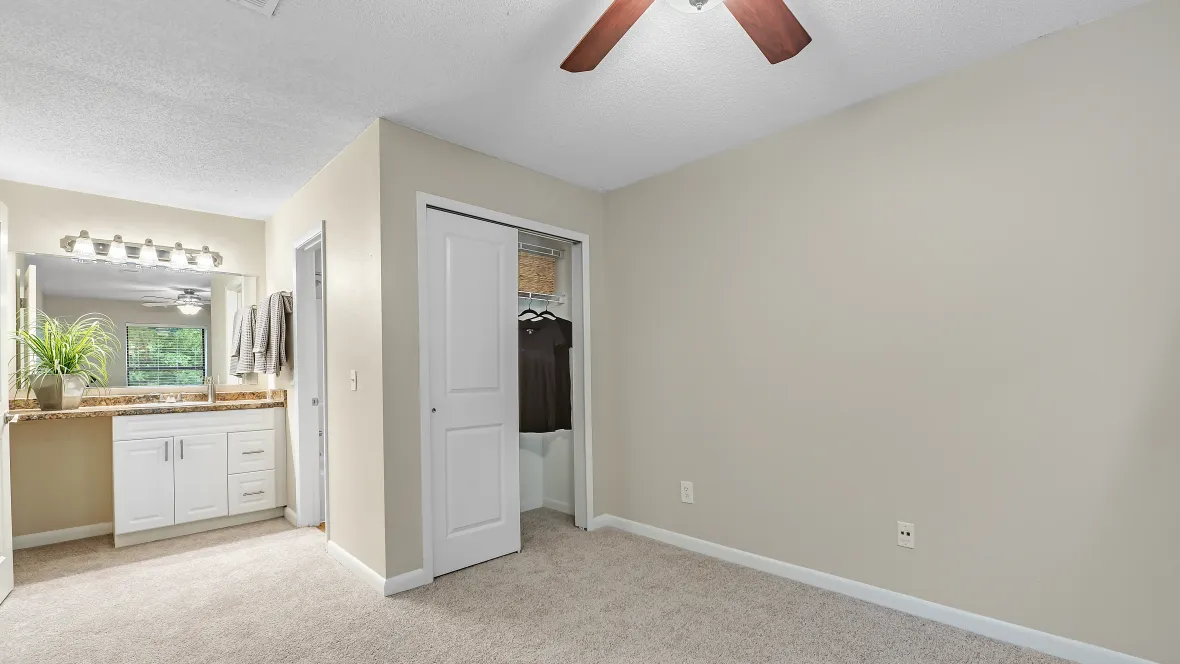 A glimpse from the grand master suite, showcasing a large closet and bath adorned with an expansive lighted vanity with exquisite storage space.