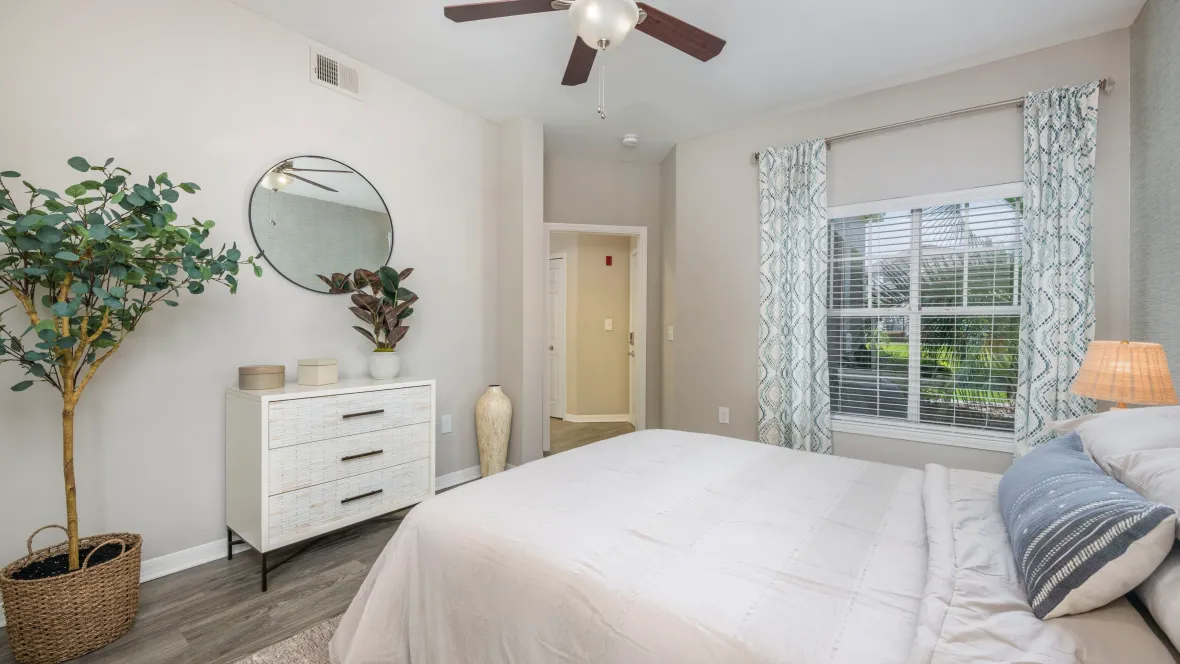 Spacious guest bedroom with abundant natural light from a double window.