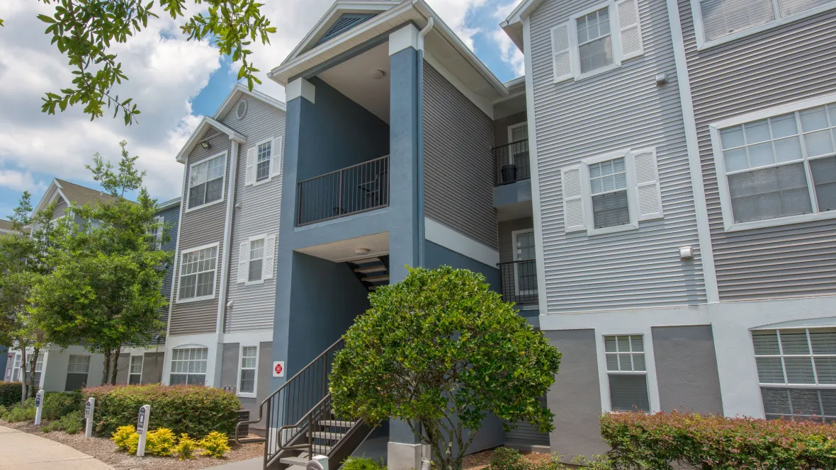 Three-story walk-up apartment buildings with calming hues of grey and blue.