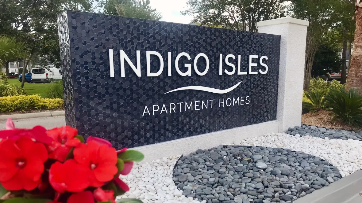  A striking mosaic monument sign adorned with landscaped river rocks, creating a bold and inviting entrance to the community.