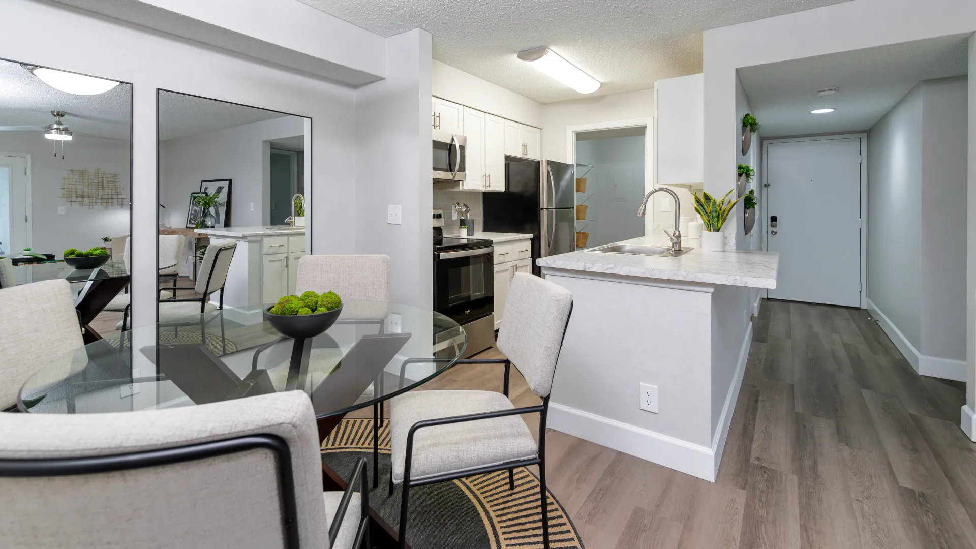 A refined dining set adorned with four cozy dining chairs next to the open kitchen.