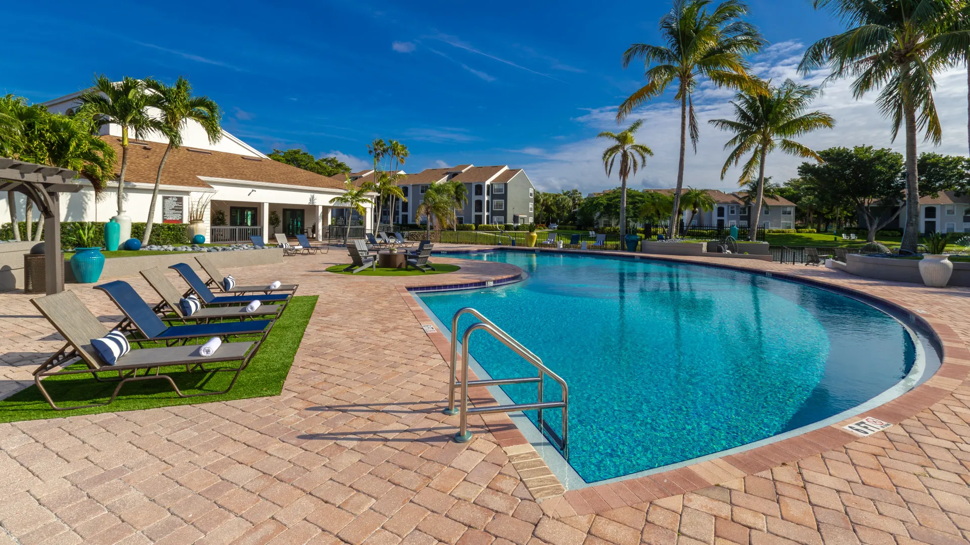 A captivating, paved pool deck surrounding a fun-shaped swimming pool with a variety of areas to soak in the sunrays or chill out with family and friends.
