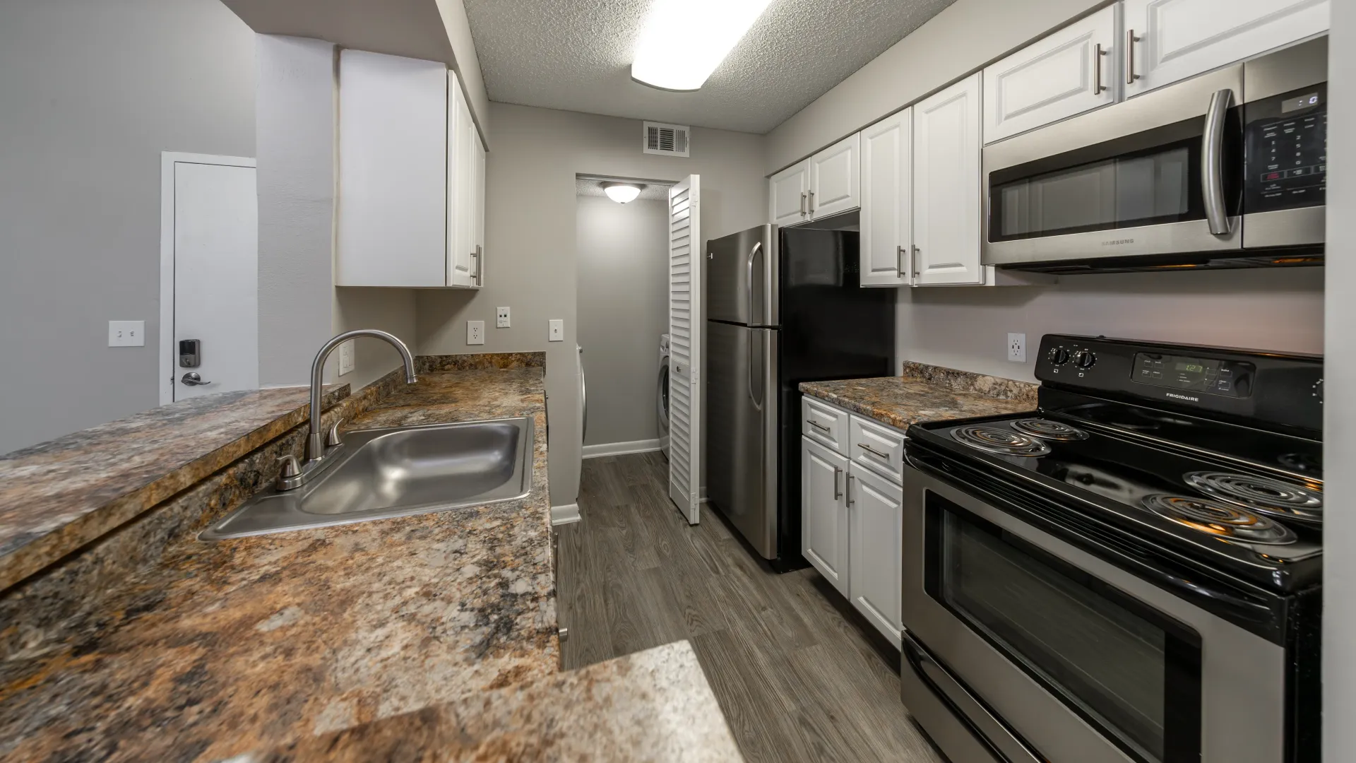 A stunning kitchen featuring gleaming stainless-steel appliances, chic cabinets for ample storage, and exquisite granite-style countertops. 