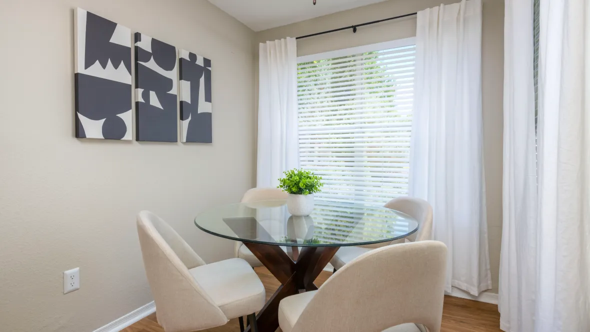Bright bonus room with many windows and a ceiling fan. Set up shown is with a small dining table and chairs.