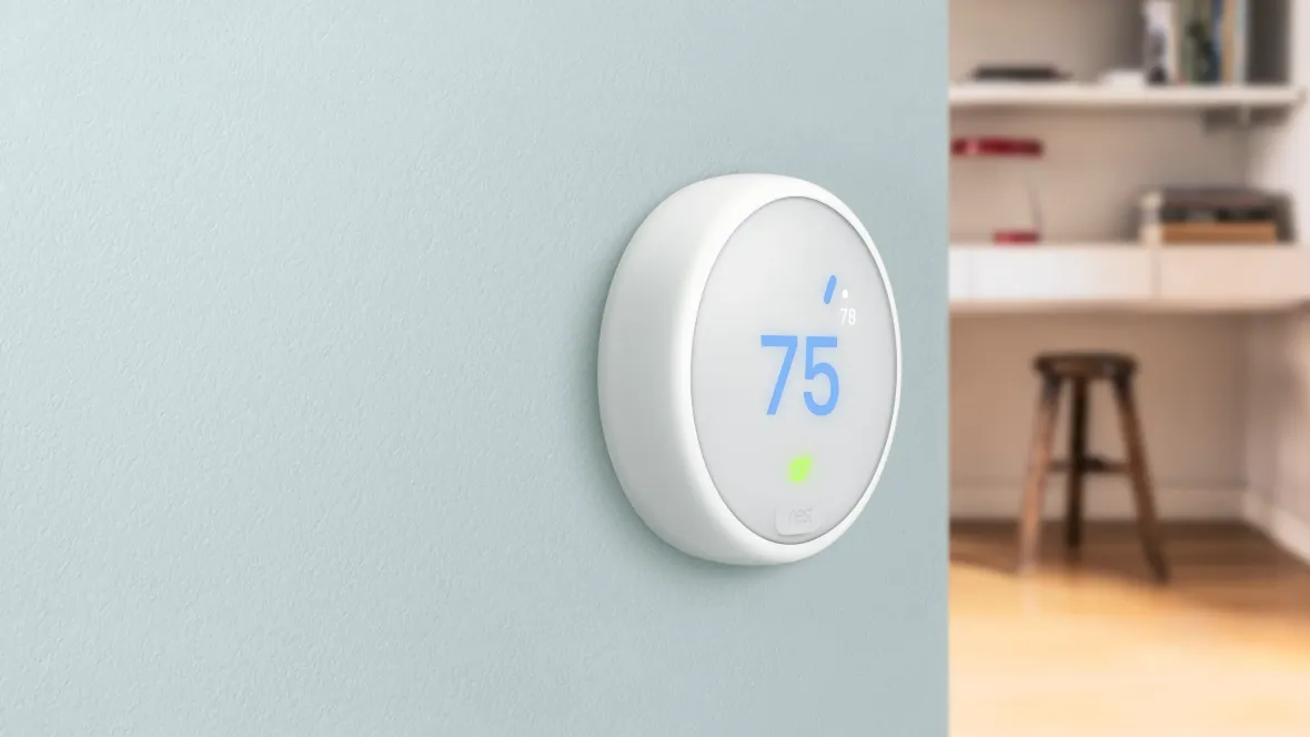 Smart thermostat control panel located on apartment wall with an emphasis on energy savings and cost-efficiency.