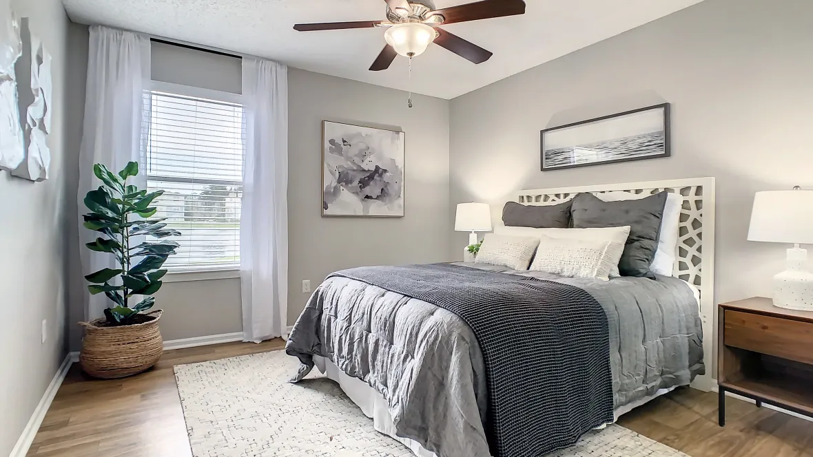 A tranquil bedroom space large enough for a king-sized bed, offers wood-style flooring, ample natural light, and a serene atmosphere ideal for peaceful slumber.