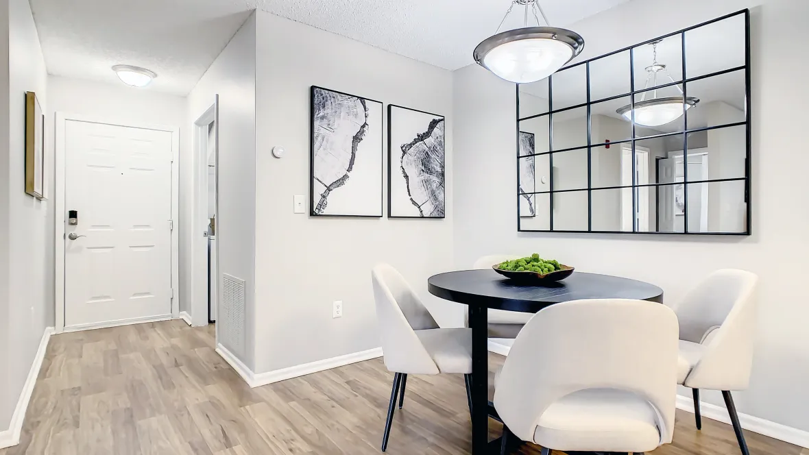 Adjacent to the kitchen, a spacious dining room adorned with warm wood-like floors and a polished-nickel lighting fixture overhead invites delightful family meals and inclusive conversations.