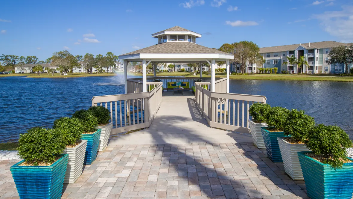 Glazed planters guide the way to the dockside gazebo extending over the lake, offering unobstructed views of the serene waters and captivating lake fountain.