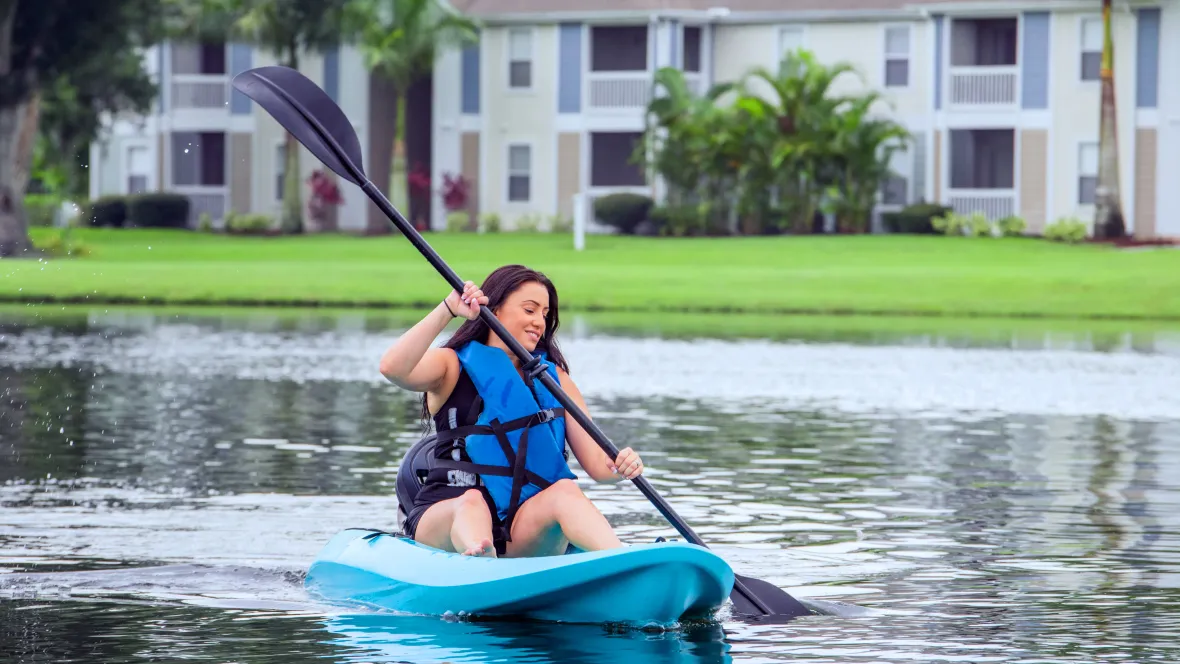 A resident joyfully paddling on the lake exploring the community's serene lake and getting some outdoor exercise – a lovely way to spend an afternoon on the water. 