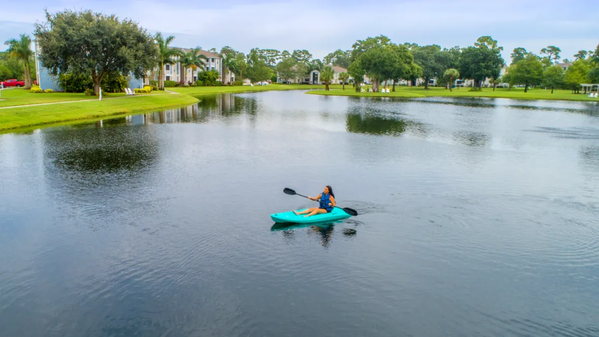 A resident enjoying kayaking activities on the tranquil waters of the community's scenic lake.