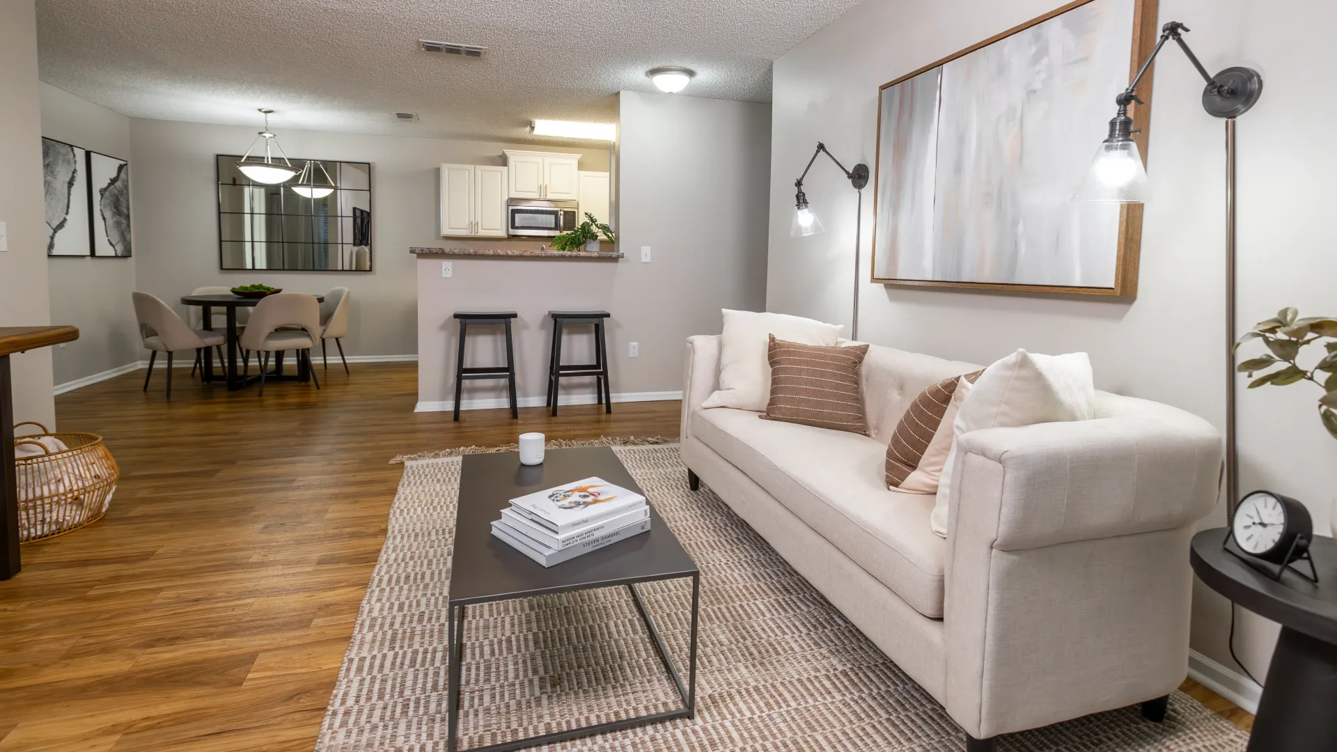 Open-concept living and dining room at Grand Oaks with breakfast bar and wood-style flooring.