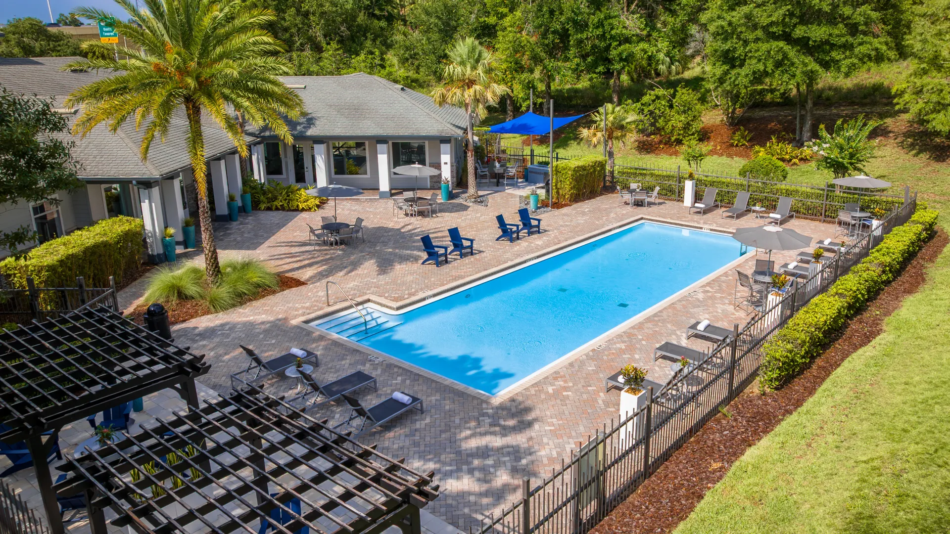 Aerial view of the Elevate 155 pool with lounge chairs, umbrellas, and lush landscaping.