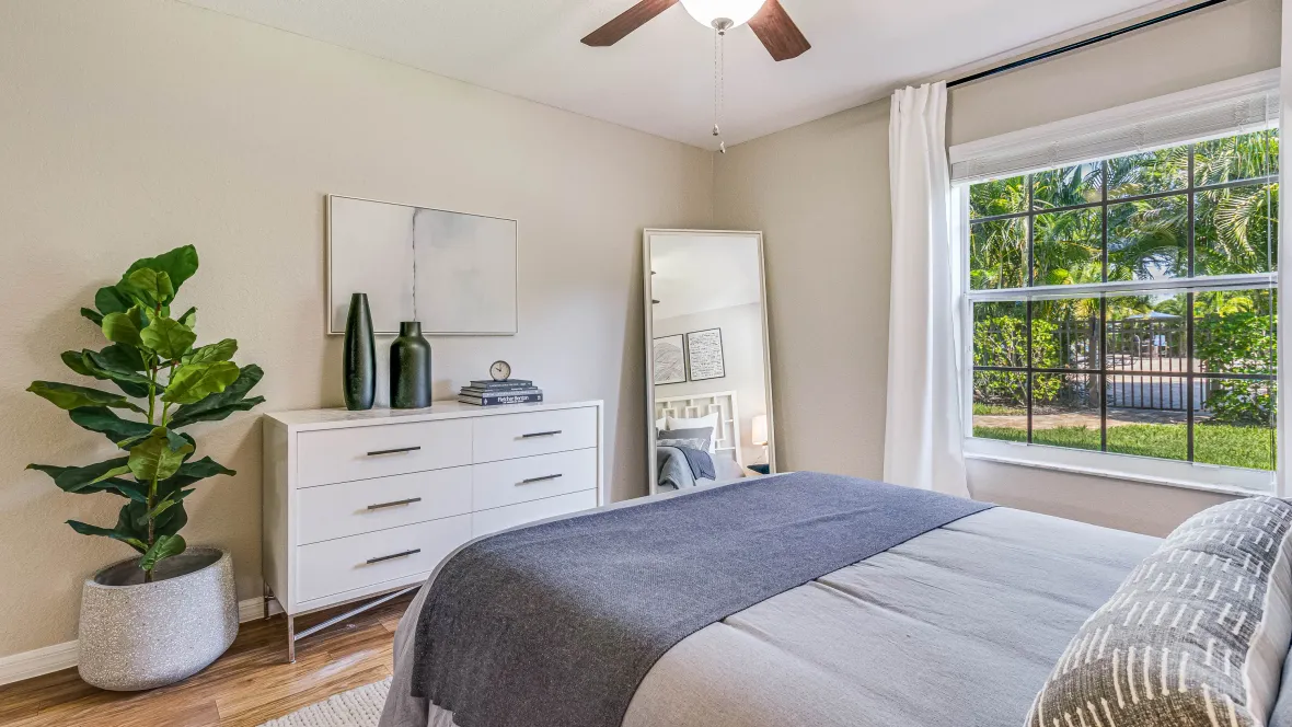A serene bedroom space adorned with an elegant multi-speed ceiling fan with radiant lighting, offering customizable comfort and an ambiance that whispers serenity.