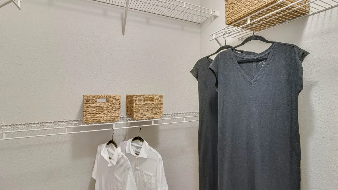 Spacious closet with wall-to-wall open wire shelving for clothes, shoes, and accessories.