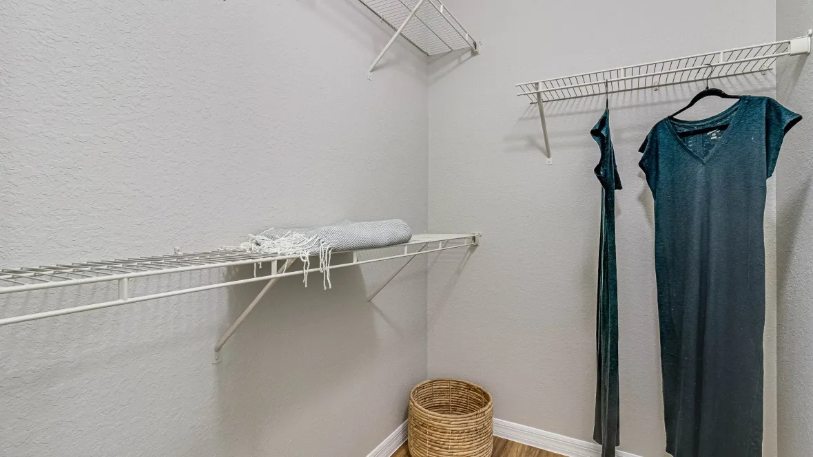 A huge walk-in closet with customized open wire shelving for versatile storage.