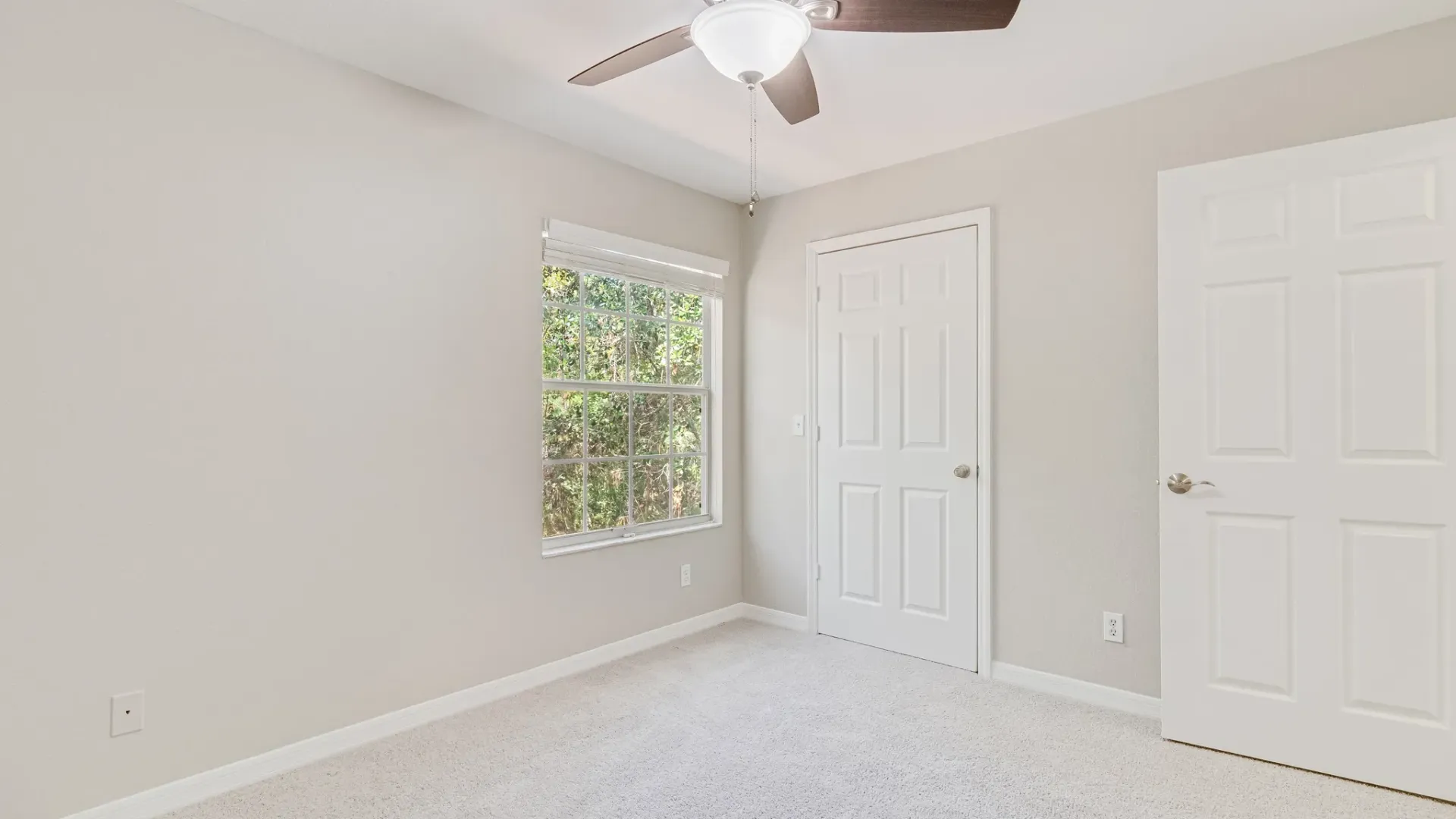 A spacious bedroom with multi-speed ceiling fan
