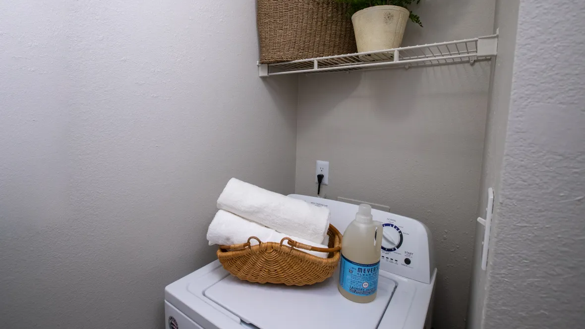 A washer in the laundry room with additional overhead storage space, conveniently tucked off to the side of the kitchen.