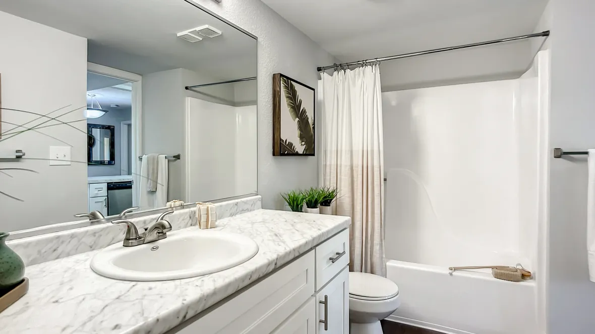 A master bathroom reminiscent of opulent spa settings, showcasing refined white shaker cabinets and prestigious white marble countertops, offering a luxurious retreat from the everyday.