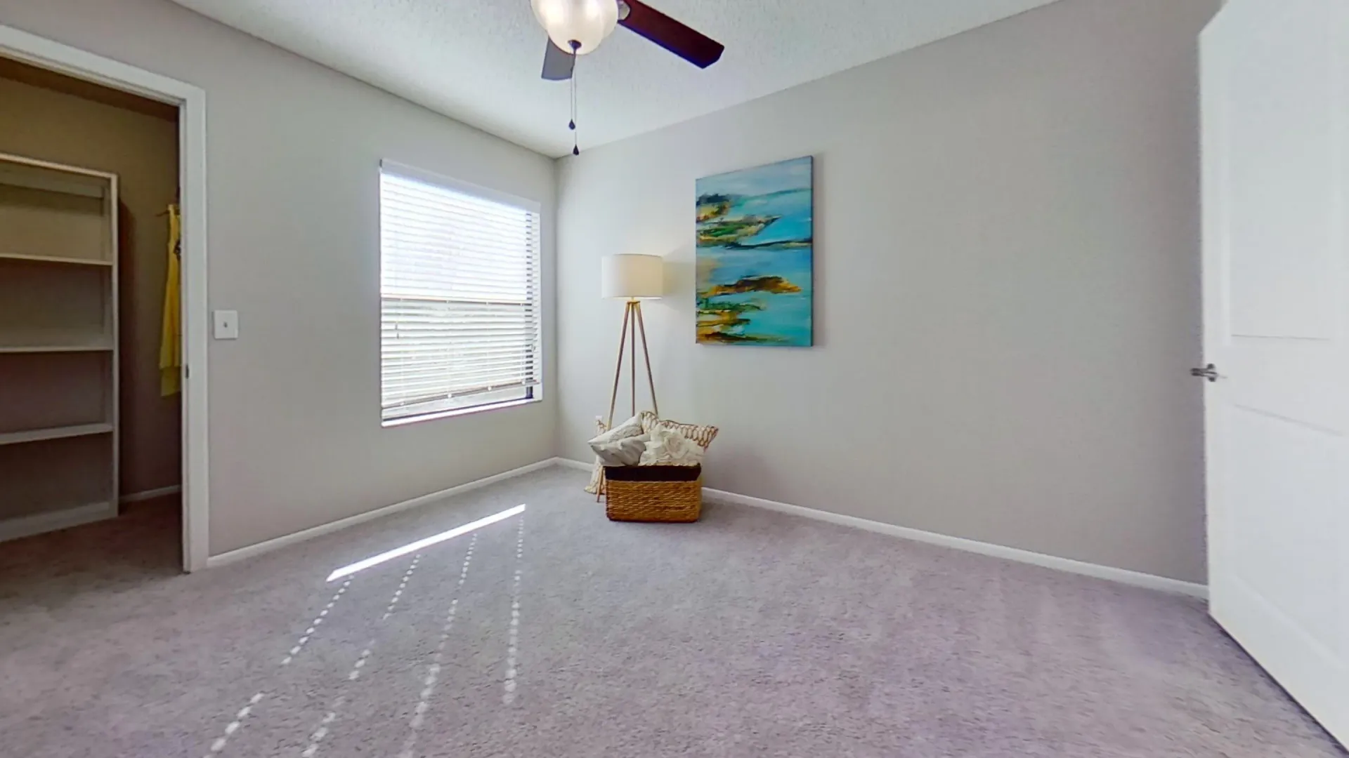 A well-lit bedroom in the Martinique Autograph floor plan, featuring a walk-in closet, carpeted flooring, a ceiling fan, and a large window with natural light.