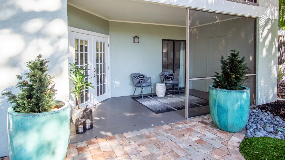 A serene ground-level patio providing privacy and relaxation, accessible through French doors from the living space.