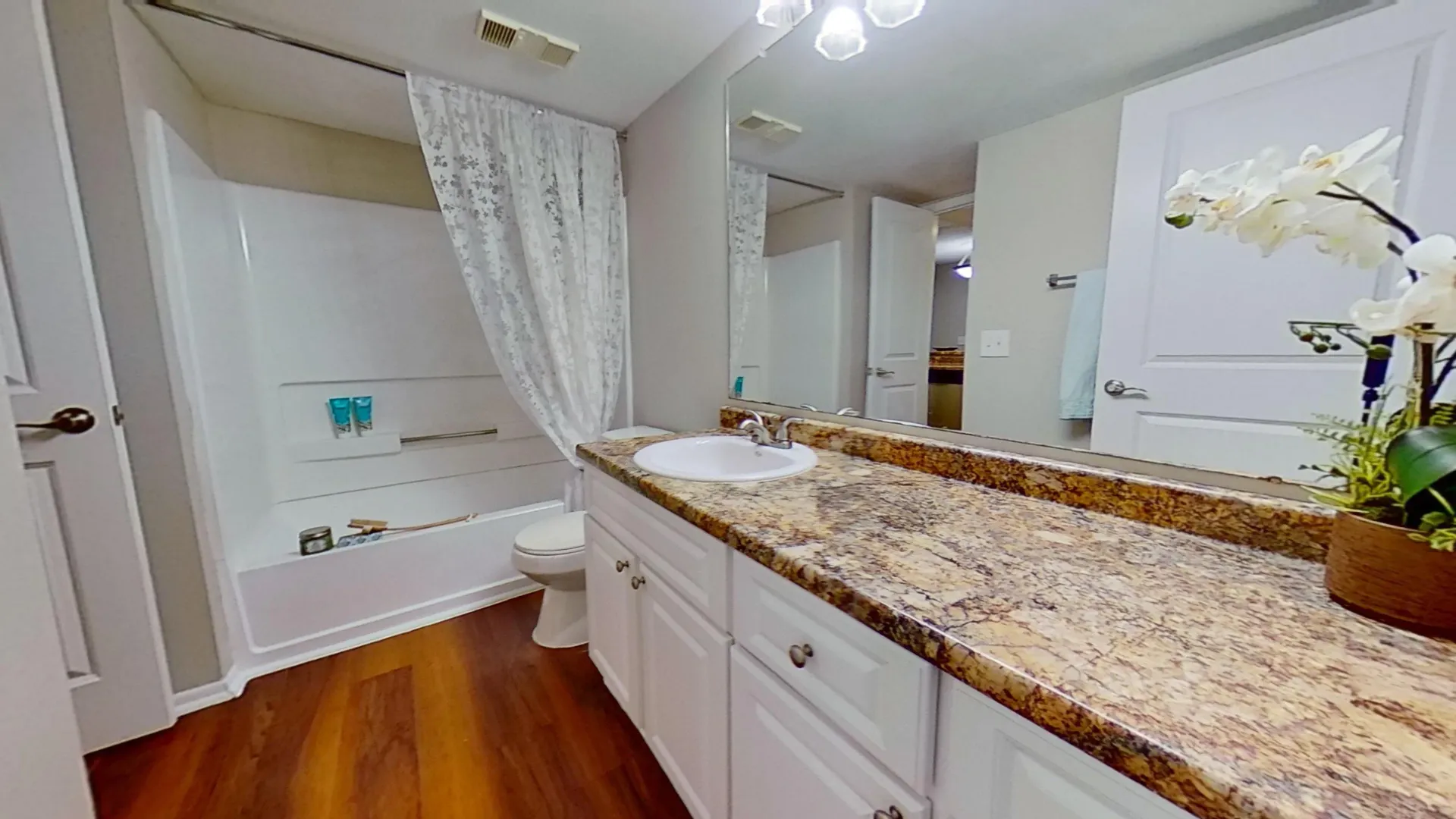 Bathroom with granite countertops and full-size tub in The Newport Autograph floor plan at River Reach Apartments.