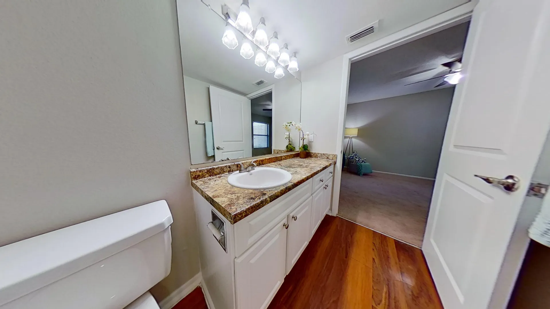 Bathroom with granite countertops and bedroom access in The Newport Autograph floor plan at River Reach Apartments.