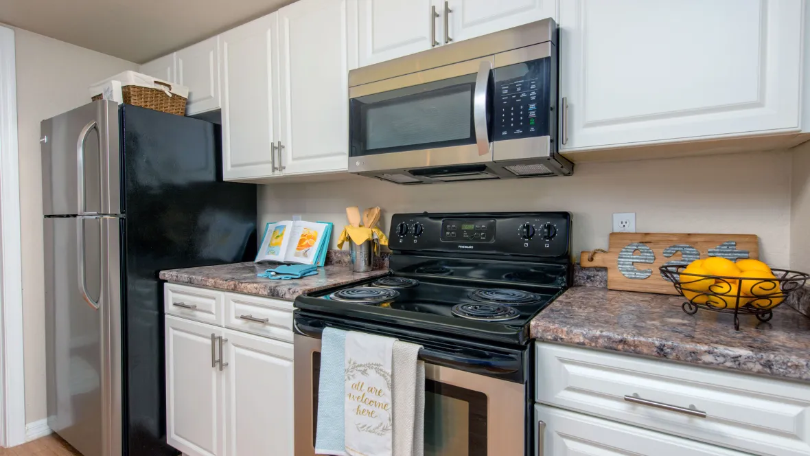 A stylish kitchen layout featuring shiny appliances, ample counterspace, and modern finishes 