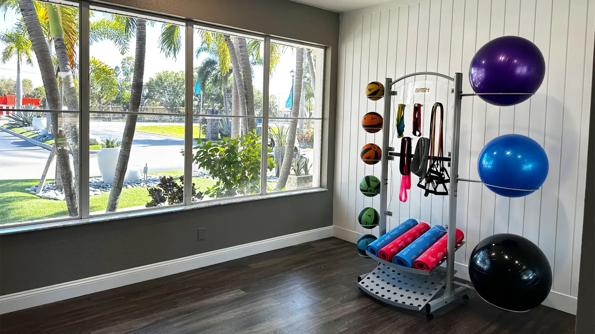 A brightly lit yoga studio with ample yoga equipment